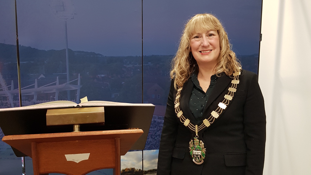 Sue Mallender, newly re-elected Mayor, standing next to the lectern holding the Book of Declaration of Acceptance of Office, after Rushcliffe full council on 20th May 2021